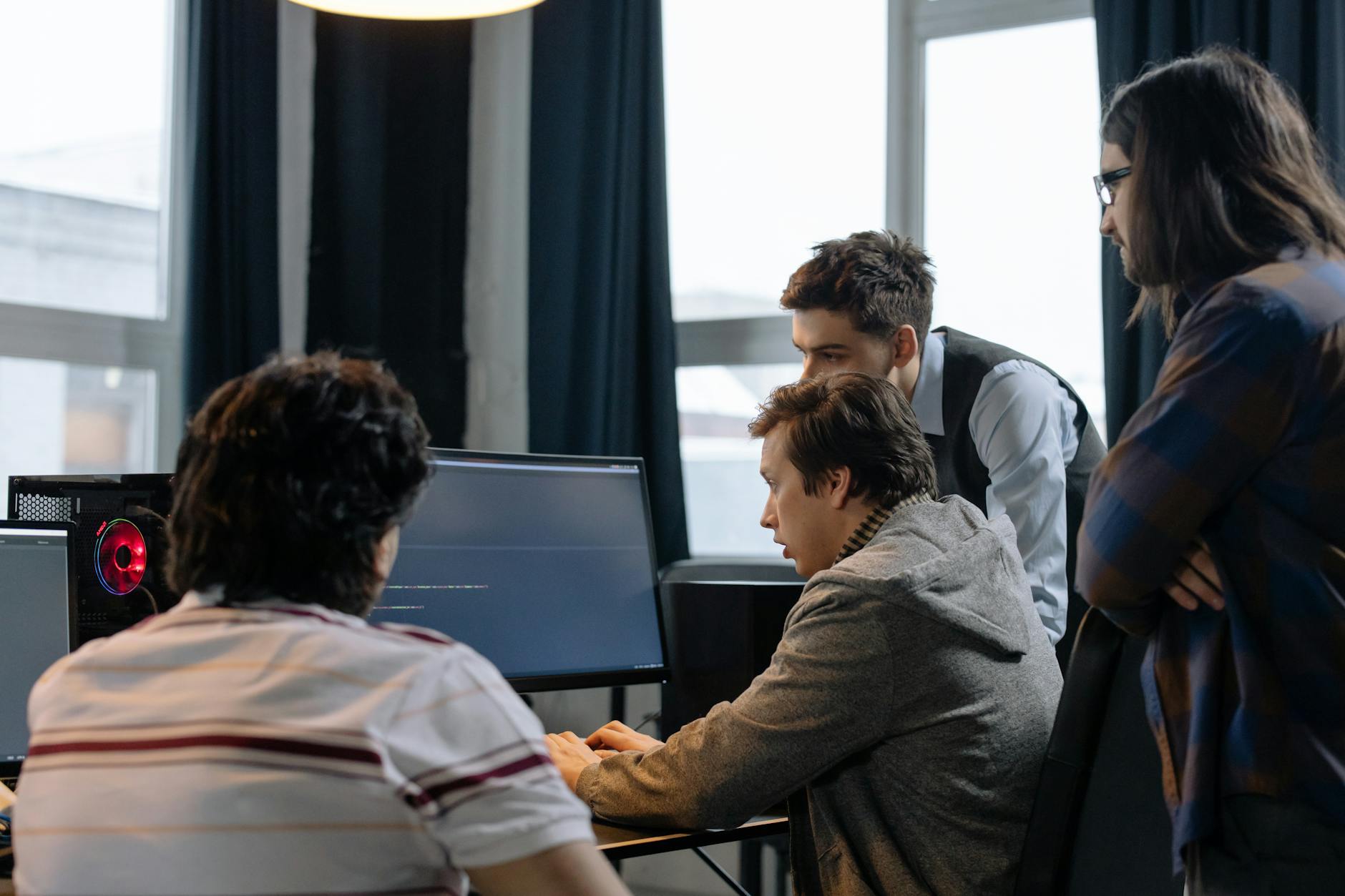 Zespół programistów przy komputerach wybierający platformę konkursową